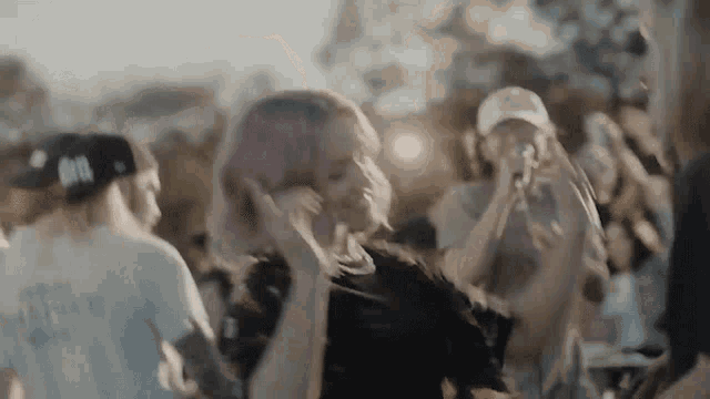 a woman with pink hair is dancing in front of a crowd of people .