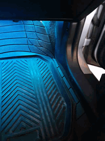 a blue light is shining on a car mat
