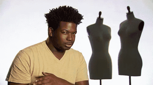 a man in a yellow shirt stands in front of a row of mannequins