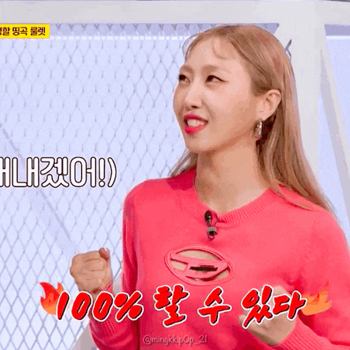 a woman in a pink sweater says 100 % in a foreign language