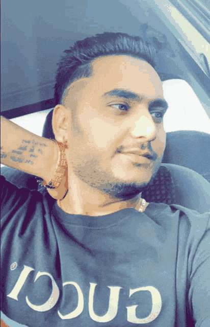 a man wearing a gucci t-shirt is taking a selfie