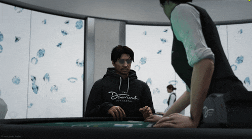 a man wearing a black diamond los santos hoodie playing poker