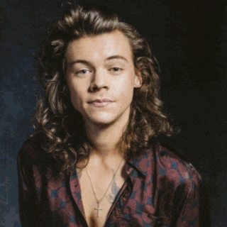 harry styles is wearing a black jacket and a white shirt .