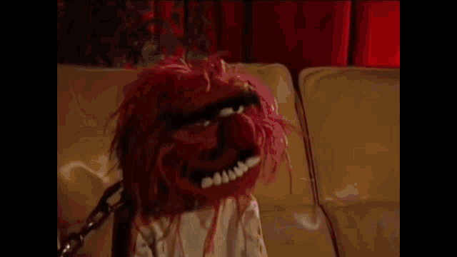 a close up of a puppet with the word drums written above it
