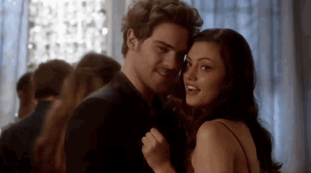 a man and a woman are dancing together in a room .