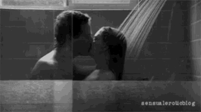 a black and white photo of a man and woman kissing