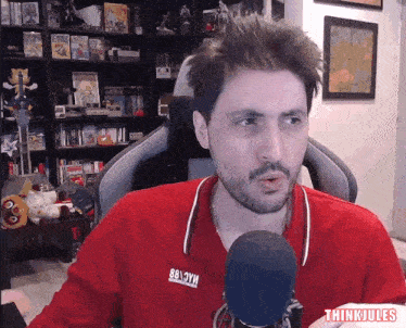 a man wearing a red shirt that says thinkjules on it