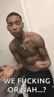 a shirtless man is standing in front of a door and says `` we fucking or nah ... '' .