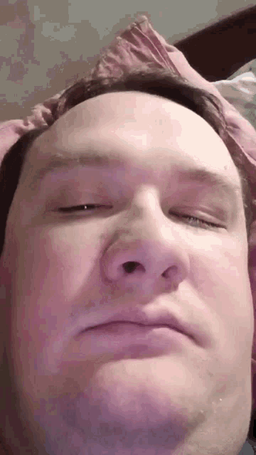 a close up of a man 's face with his eyes closed and his nose visible