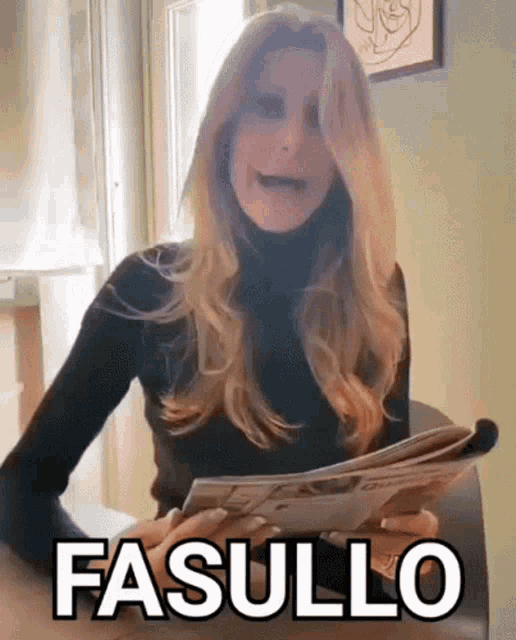 a woman is sitting at a table holding a newspaper and making a funny face with the word fasullo written in black