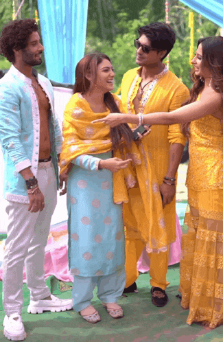 a group of people standing next to each other and one of them is wearing a yellow dress