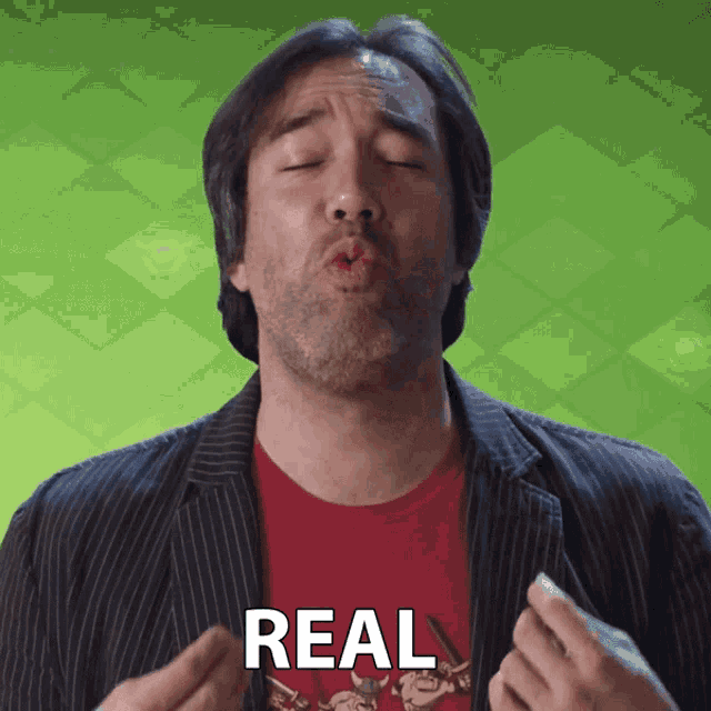 a man blowing a kiss with the word real written on his chest