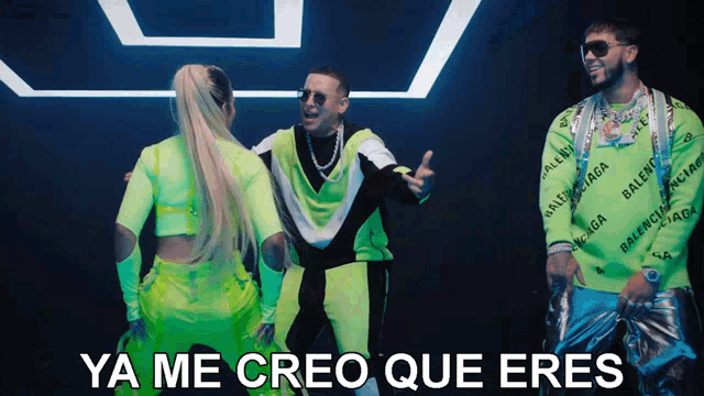 a man in a neon green balenciaga shirt stands next to two women