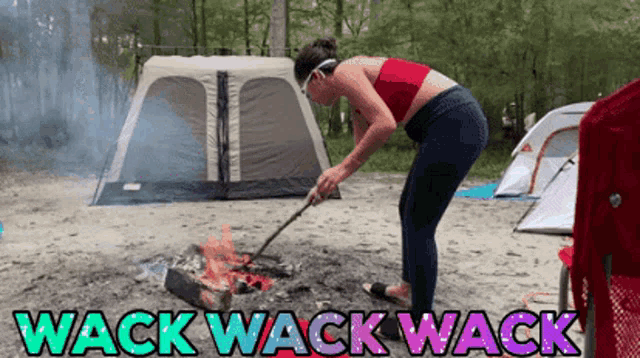 a woman is standing in front of a campfire with the words wack wack wack on the bottom