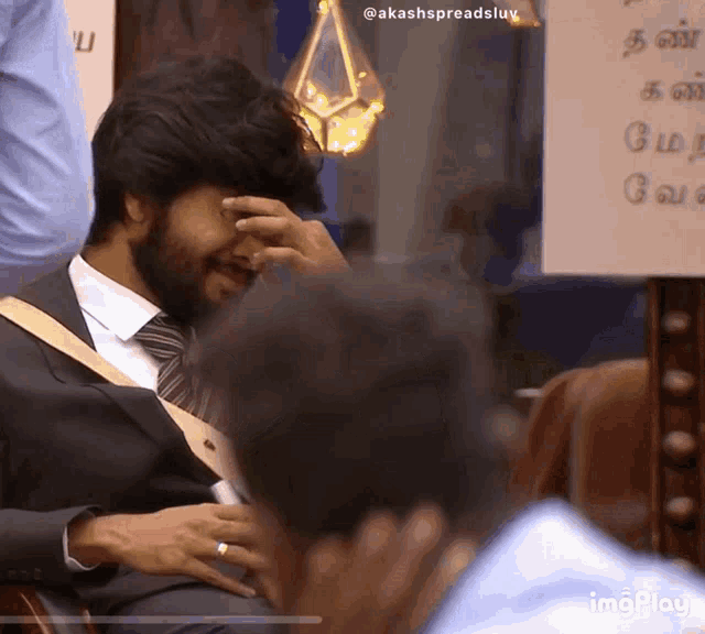 a man in a suit and tie is covering his face