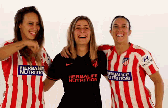 three women wearing red and white striped shirts with herbalife nutrition on the front