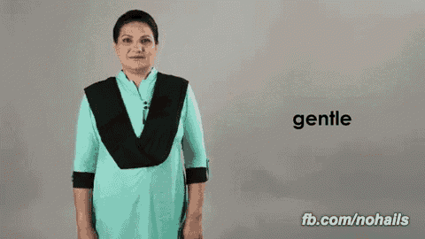 a woman in a blue dress stands in front of a sign that says " gentle "