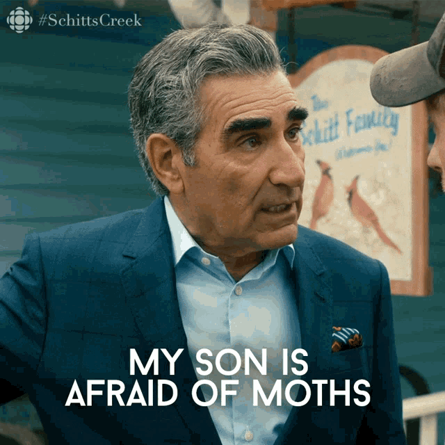 a man in a suit has the words " my son is afraid of moths " on his face