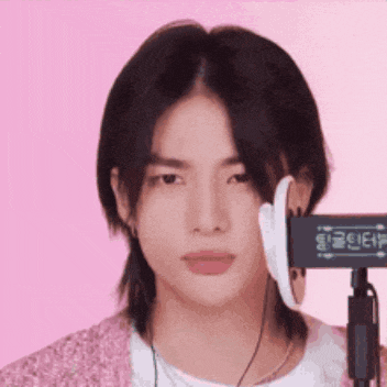 a young man with long hair is wearing headphones and a microphone .