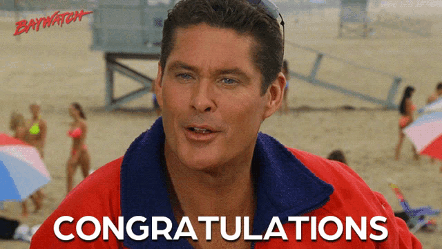 a man in a red jacket says congratulations on a beach