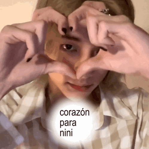 a person making a heart shape with their hands with the words corazon para nini written below
