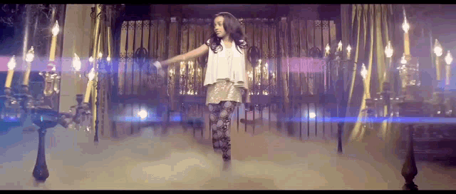 a girl is dancing in a room with candles and smoke coming out of it