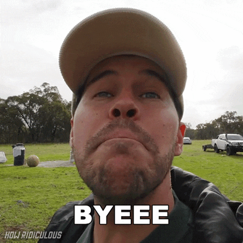a man in a hat says byeee in front of a field