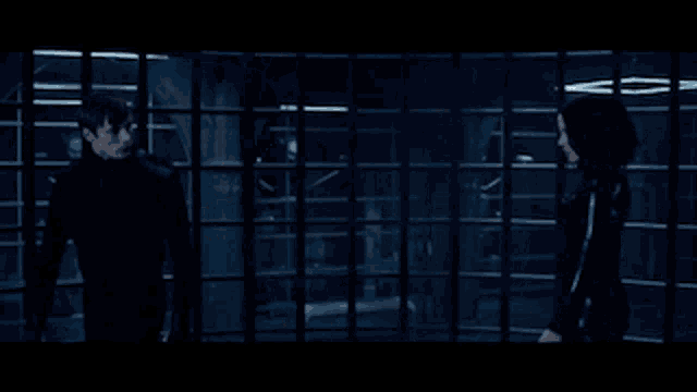 a man and a woman are fighting in a dark room with lights behind them