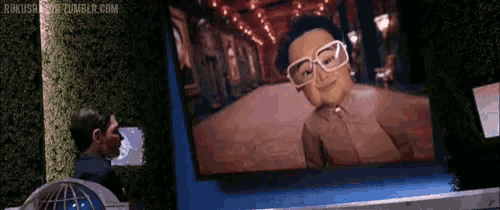 a man is looking at a screen with a picture of a woman with glasses on it