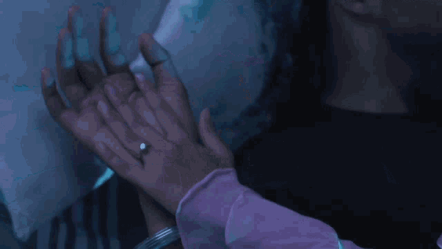 a woman in a pink shirt is laying on a bed with a man