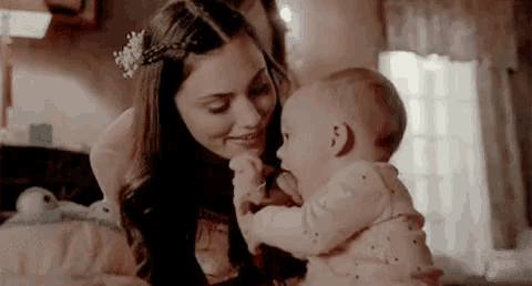 a woman is holding a baby in her arms in a bedroom .