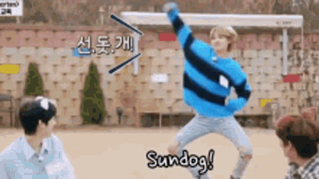 a boy in a blue and black striped sweater is jumping in the air while another boy looks on .