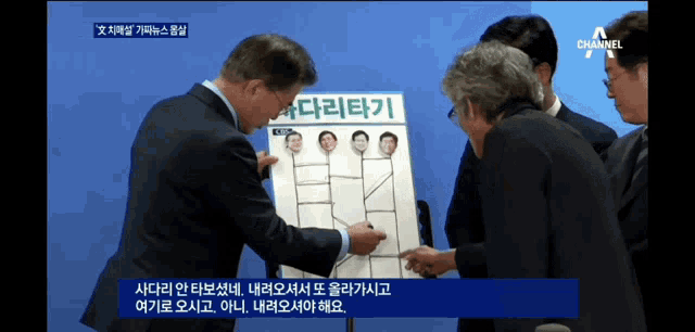a group of men standing around a board that says channel a on it