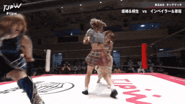 two women are wrestling in a ring with the letters tjpw on the bottom