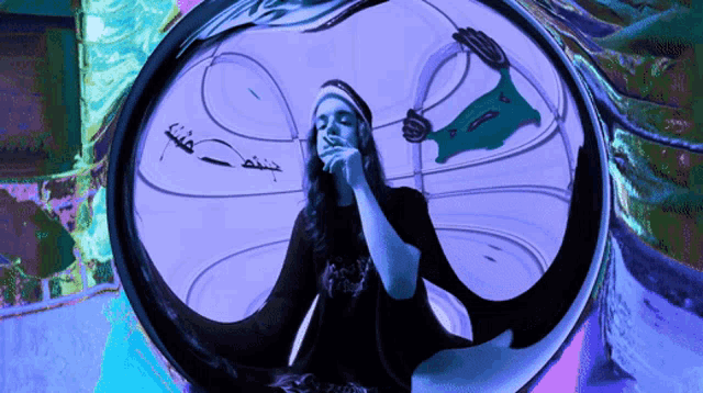 a woman smoking a cigarette in front of a colorful background with arabic writing