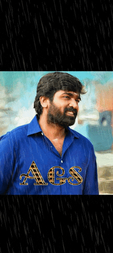 a man with a beard wearing a blue shirt that says aes