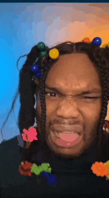 a man with colorful beads in his hair is making a face