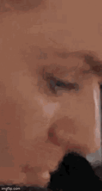 a close up of a man 's face with his eyes closed and his nose visible .