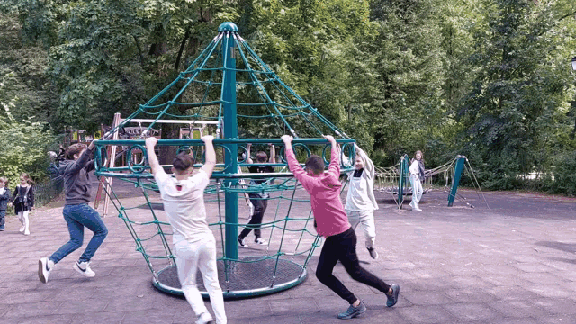 a group of children are playing in a playground with trees in the background
