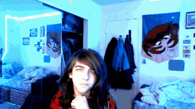 a boy with long hair is standing in front of a mirror in a room