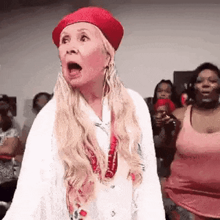 a woman wearing a red beret is making a funny face .