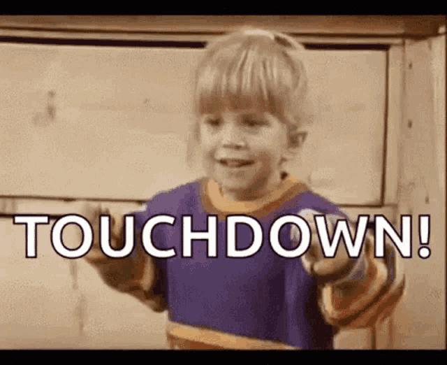a little boy is pointing at the camera and saying touchdown !