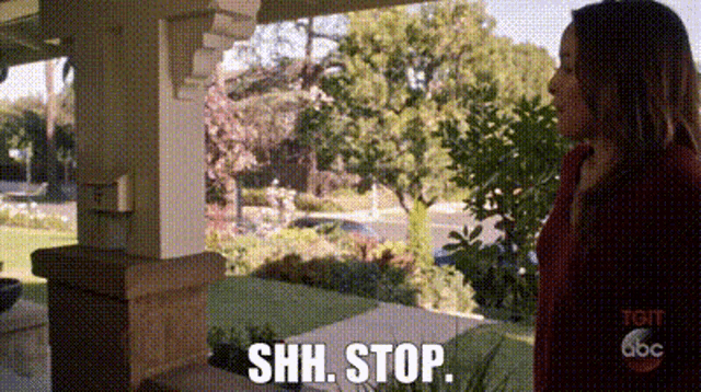a woman standing on a porch with the words shh stop written on it