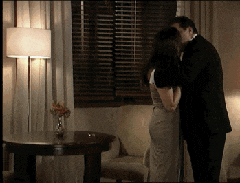 a man and woman are kissing in a living room