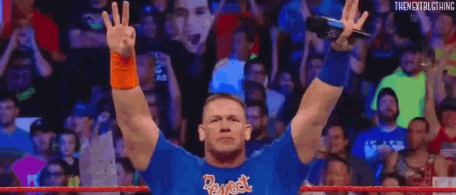 john cena is saluting in front of a crowd while wearing a blue shirt .