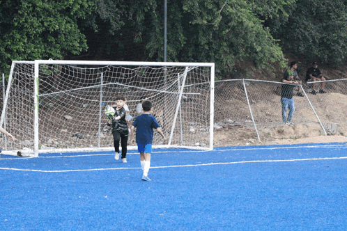 a boy in a blue shirt is playing soccer