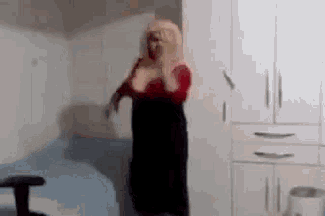 a woman is dancing in a bedroom in front of a wardrobe and a bed .