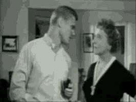 a man and woman are standing next to each other in a living room