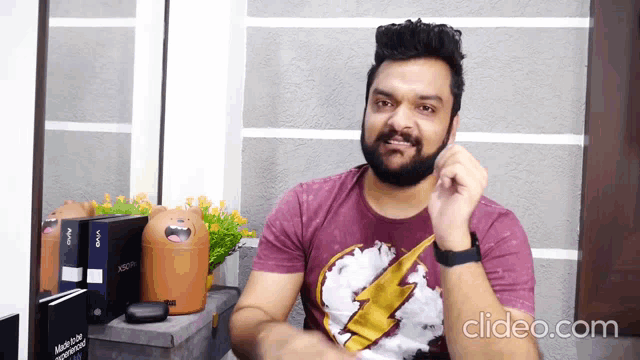 a man with a beard is wearing a shirt with a lightning bolt on it .