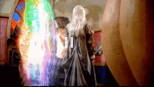 a woman with long white hair is standing in front of a mirror with a rainbow of light coming out of it
